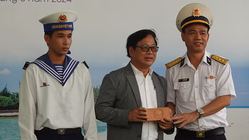 Thượng tá Hà Văn Hậu (bìa phải), Phó Chính ủy Lữ đoàn 125 Hải quân tặng cho Đường sách thành phố Thủ Đức viên gạch Trường Sa.
