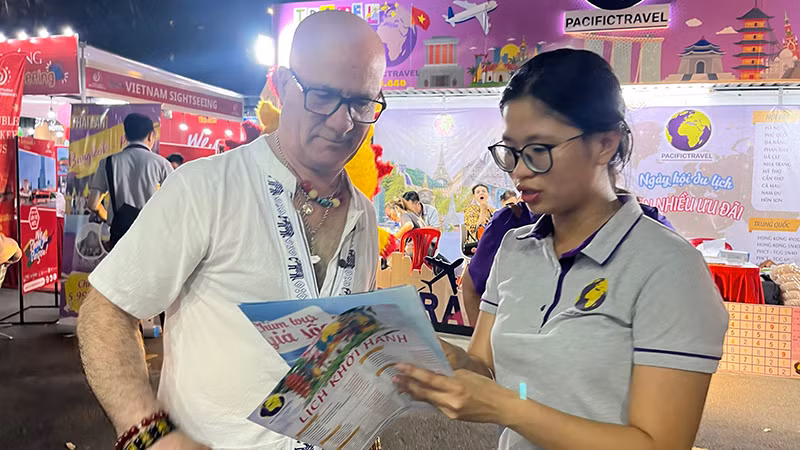 Khách nước ngoài tìm hiểu các tour du lịch trong ngày khai mạc.
