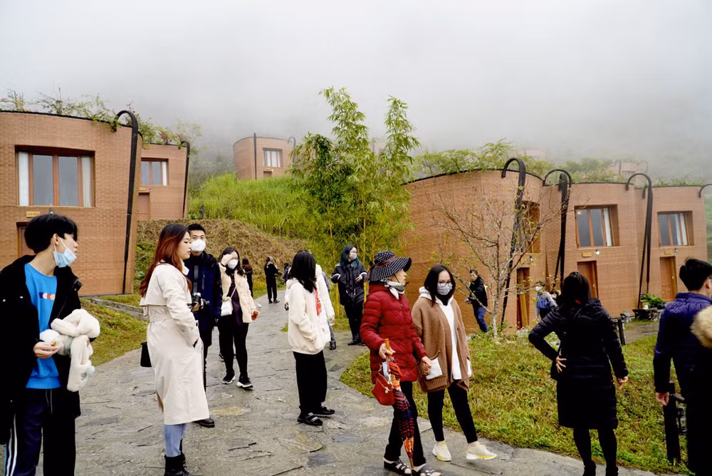 Du khách thích thú ngắm những ngôi nhà hình quẩy tấu tại Khu nghỉ dưỡng H'Mông Village.