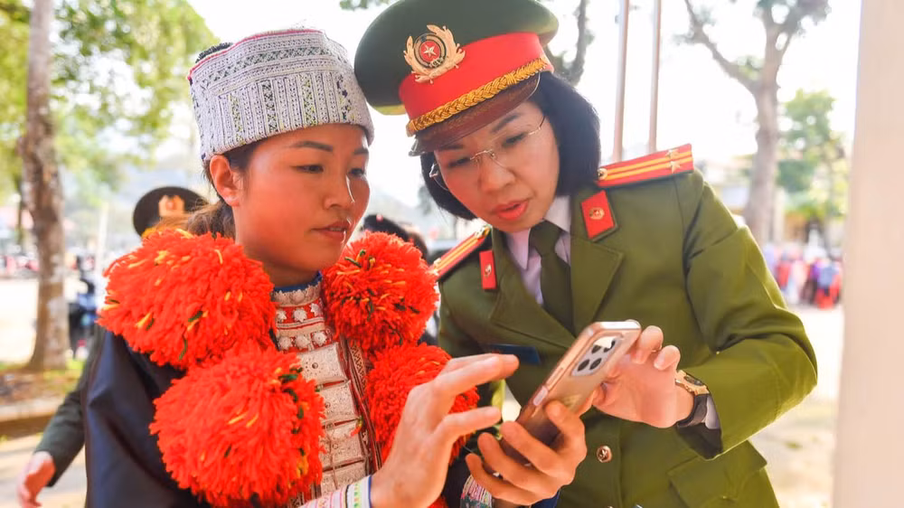 Phụ nữ Công an tỉnh Hà Giang hướng dẫn người dân quét mã QR phổ biến giáo dục pháp luật. (Ảnh: KHÁNH LINH)