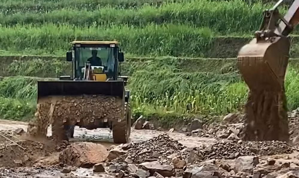 Chính quyền các địa phương cử nhân lực, máy móc san gạt đất đá để sớm thông tuyến cho người dân đi lại.