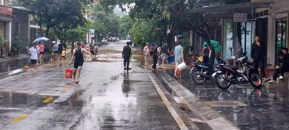 Người dân thành phố Hà Giang vệ sinh đường phố sau khi nước rút.