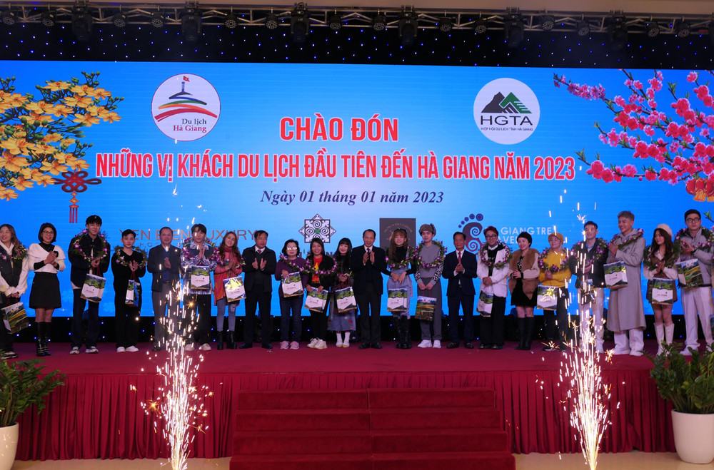 Lãnh đạo tỉnh Hà Giang tặng hoa và quà chúc mừng những vị khách đầu tiên.