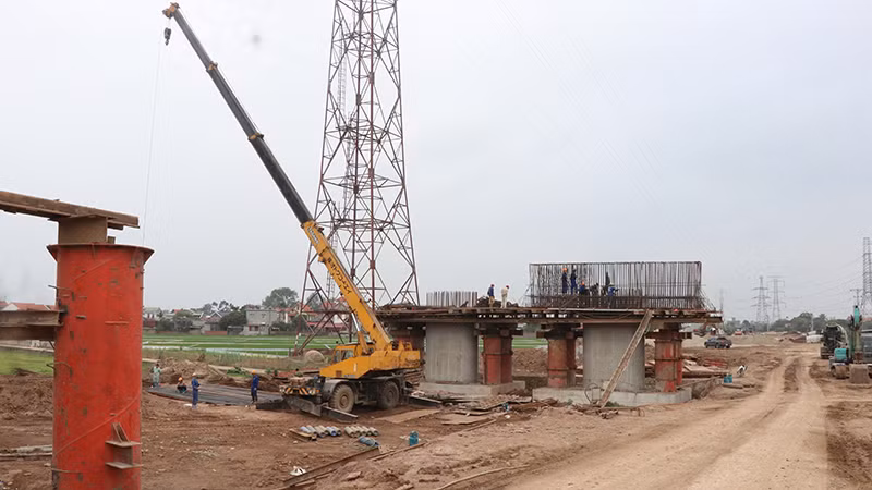 Công nhân thi công phần trụ cột cầu Kênh Vàng. (Ảnh TTXVN)