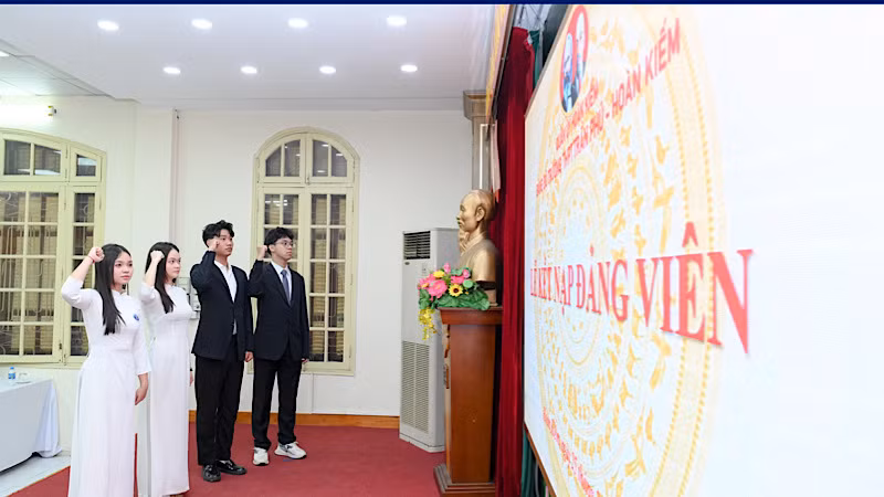 Bốn Đảng viên mới đọc lời tuyên thệ trước Quốc kỳ, Đảng kỳ, chân dung Chủ tịch Hồ Chí Minh.