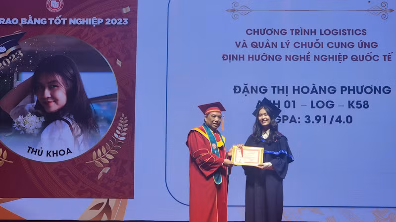 PGS,TS Bùi Anh Tuấn, Hiệu trưởng Trường đại học Ngoại thương trao giấy khen và huy hiệu cho thủ khoa tốt nghiệp.