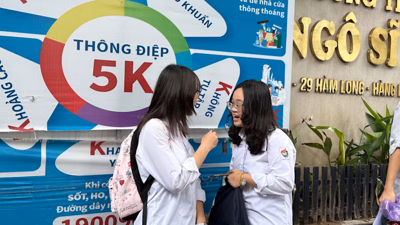 Thí sinh trao đổi bài thi sau khi kết thúc môn thi Ngữ văn tại điểm thi Trường THCS Ngô Sĩ Liên, Hoàn Kiếm, Hà Nội. (Ảnh: Quỳnh Nguyễn)