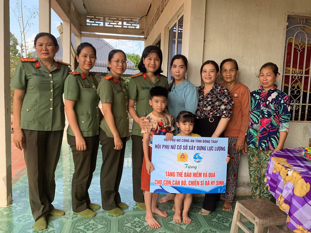 Hội Phụ nữ cơ sở Xây dựng lực lượng tặng thẻ bảo hiểm và quà cho con Thiếu tá Hồ Tấn Dương. (Ảnh: ĐOÀN DIỂU)