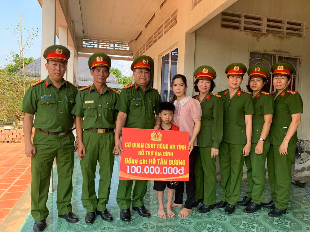 Lãnh đạo, chỉ huy khối điều tra trao tượng trưng số tiền 100 triệu đồng cho cháu Hồ Gia Bảo. (Ảnh: ĐOÀN DIỂU)