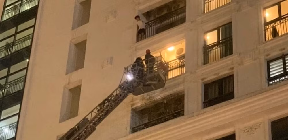 Cảnh sát dùng xe thang tiếp cận và giải cứu người thanh niên có ý định tự tử. (Ảnh: Đội Cảnh sát Phòng cháy chữa cháy và Cứu nạn cứu hộ, Công an quận Nam Từ Liêm)