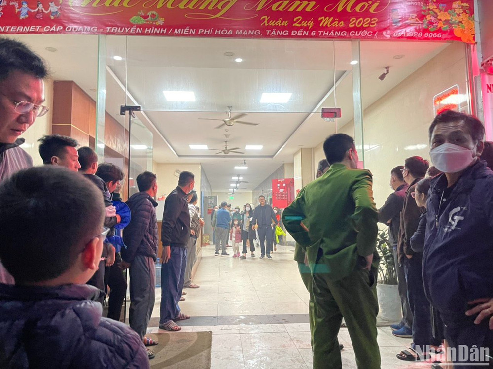 Cảnh sát hướng dẫn người dân thoát xuống sân chung cư trong đêm. (Ảnh: Đ.N)