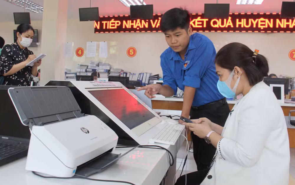 Đoàn viên thanh niên huyện Nhà Bè hướng dẫn người dân thực hiện dịch vụ công trực tuyến.