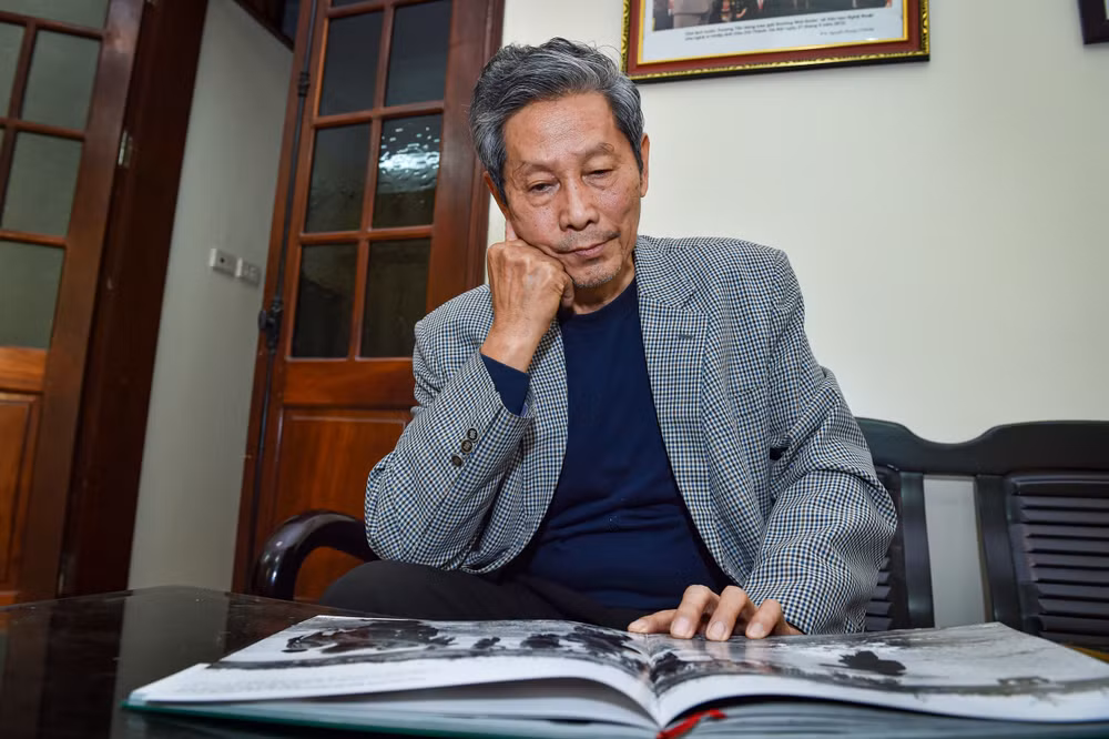 Nghệ sĩ nhiếp ảnh Chu Chí Thành trầm tư bên cuốn sách ảnh Ký ức chiến tranh của mình.
