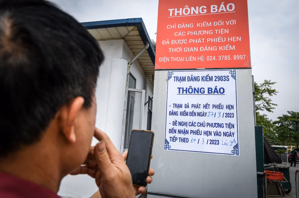 Anh Phùng Văn Vinh chán nản khi đọc tấm bảng thông báo tại Trạm Đăng kiểm 29-03S. (Ảnh: Thành Đạt)