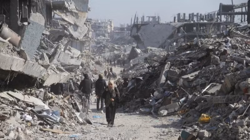 Người dân Palestine trên một con phố có những tòa nhà bị phá hủy tại trại tị nạn Jabalia ở phía bắc Dải Gaza, vào ngày 29/1/2025. (Ảnh: Tân Hoa xã)