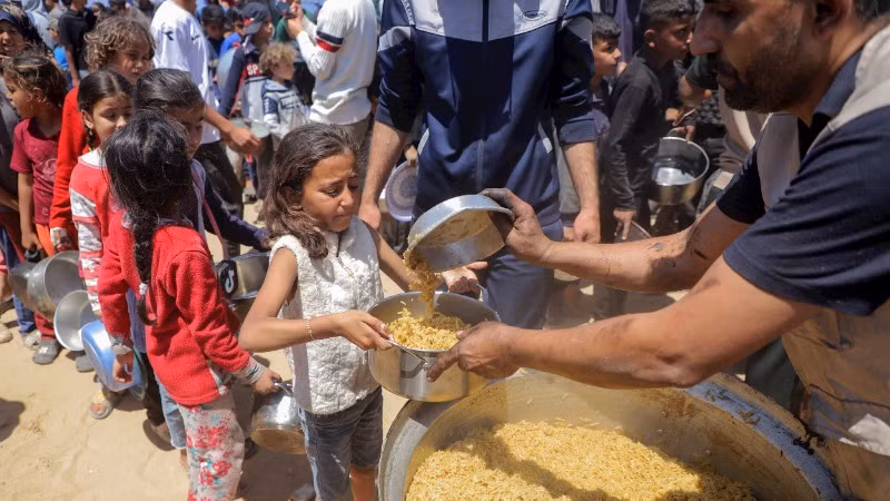 Trẻ em Palestine nhận thực phẩm viện trợ ở Dải Gaza. (Ảnh TÂN HOA XÃ)