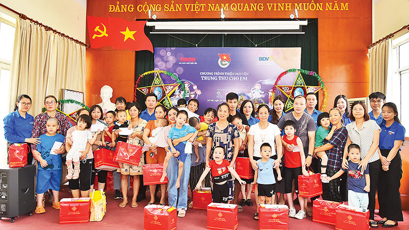 Đoàn viên, thanh niên Báo Nhân Dân và Ngân hàng BIDV trao quà Trung thu tặng các em nhỏ đang điều trị tại Bệnh viện Phục hồi chức năng Hà Nội. (Ảnh THỦY NGUYÊN)