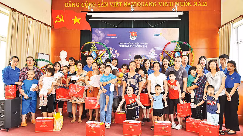 Đoàn viên, thanh niên Báo Nhân Dân và Ngân hàng BIDV trao quà Trung thu tặng các em nhỏ đang điều trị tại Bệnh viện Phục hồi chức năng Hà Nội. (Ảnh THỦY NGUYÊN)
