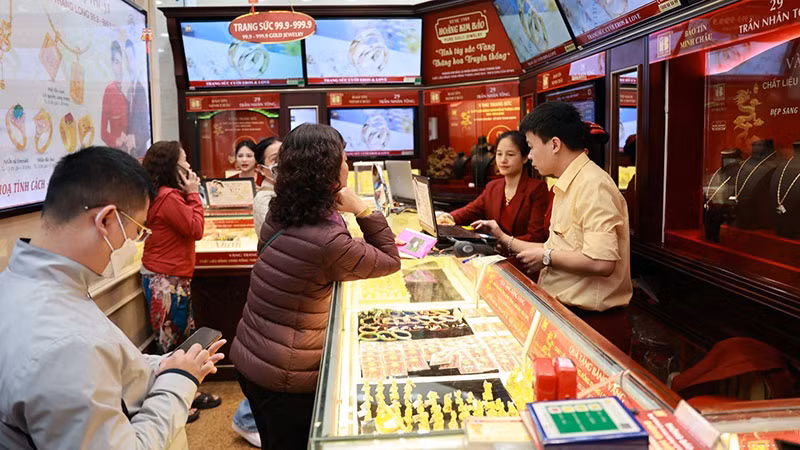 Khách hàng giao dịch mua bán vàng tại một cửa hàng của Công ty Bảo Tín Minh Châu ở Hà Nội. (Ảnh MINH ANH)
