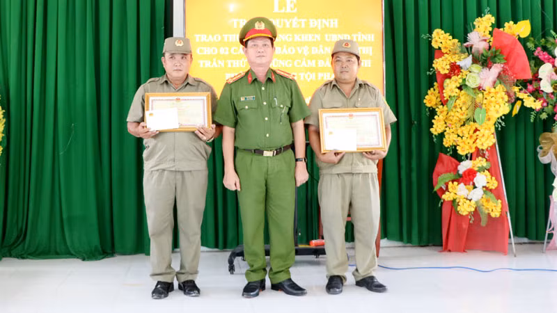Đại tá Diệp Văn Thế, Phó Giám đốc Công an tỉnh Kiên Giang trao bằng khen của Ủy ban nhân dân tỉnh cho ông Cao Thế Nhiên và ông Phạm Hoài Ân.