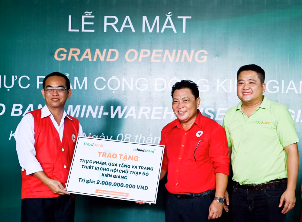 Đại diện Food Bank Việt Nam trao biển tượng trưng tặng thực phẩm, quà tặng và trang thiết bị trị giá 2 tỷ đồng đưa vào vận hành kho thực phẩm cộng đồng Kiên Giang.