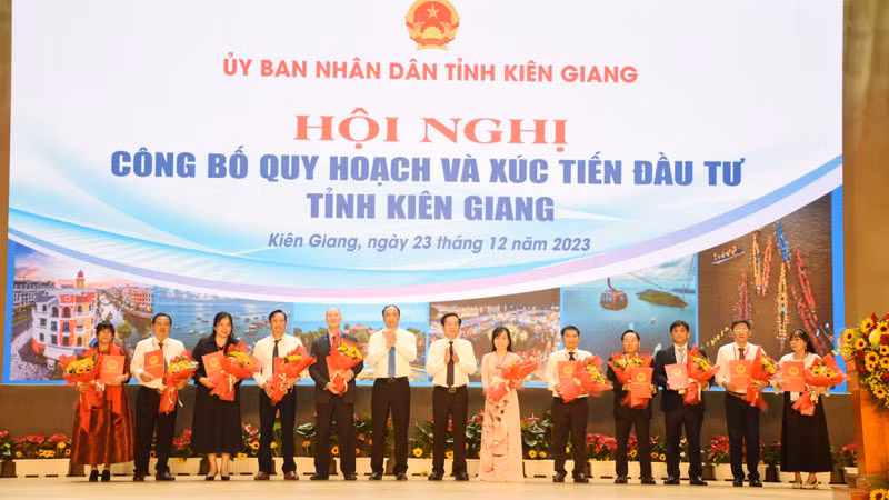 Lãnh đạo tỉnh Kiên Giang trao quyết định chủ trương đầu tư và tặng hoa cho các nhà đầu tư tại hội nghị.