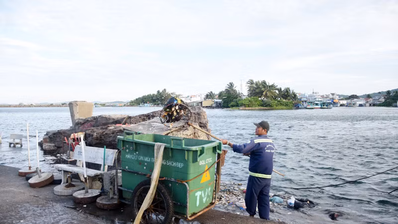 Công nhân thu gom rác ở sông Dương Đông, thành phố Phú Quốc.
