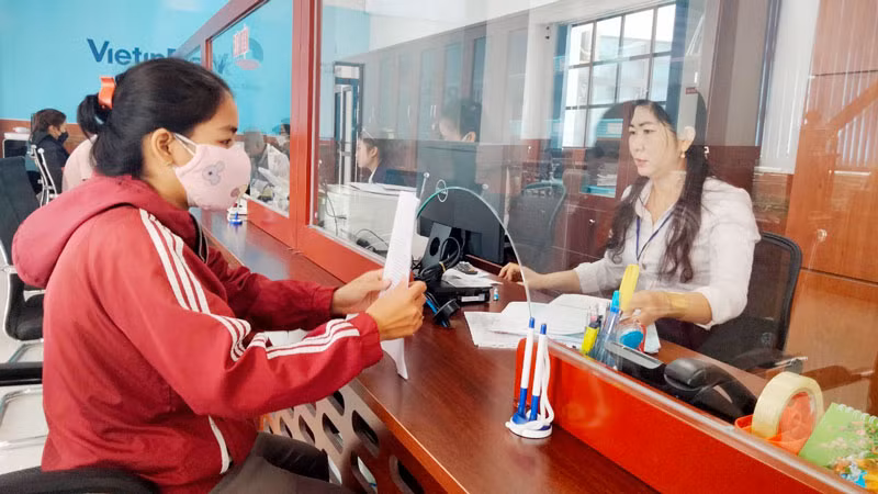 Công chức Trung tâm phục vụ hành chính công tỉnh Kiên Giang giải quyết thủ tục hành chính cho người dân. (Ảnh: QUỐC TRINH)