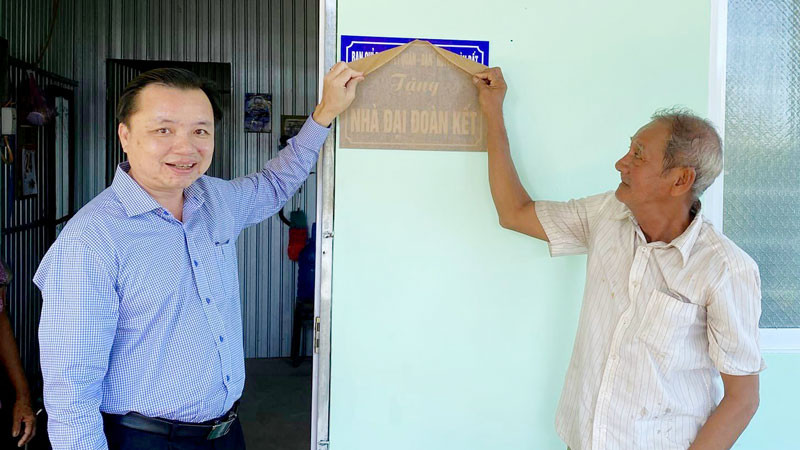 Lãnh đạo huyện Hòn Đất, tỉnh Kiên Giang và người dân thực hiện nghi thức bàn giao nhà Đại đoàn kết.