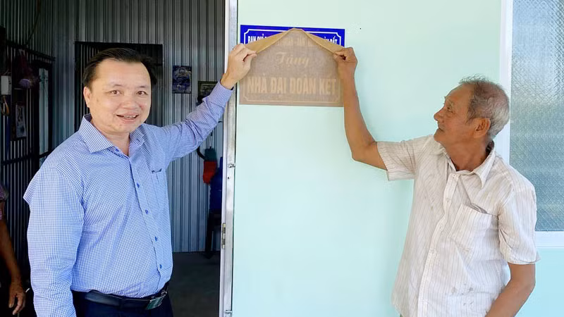 Lãnh đạo huyện Hòn Đất, tỉnh Kiên Giang và người dân thực hiện nghi thức bàn giao nhà Đại đoàn kết.