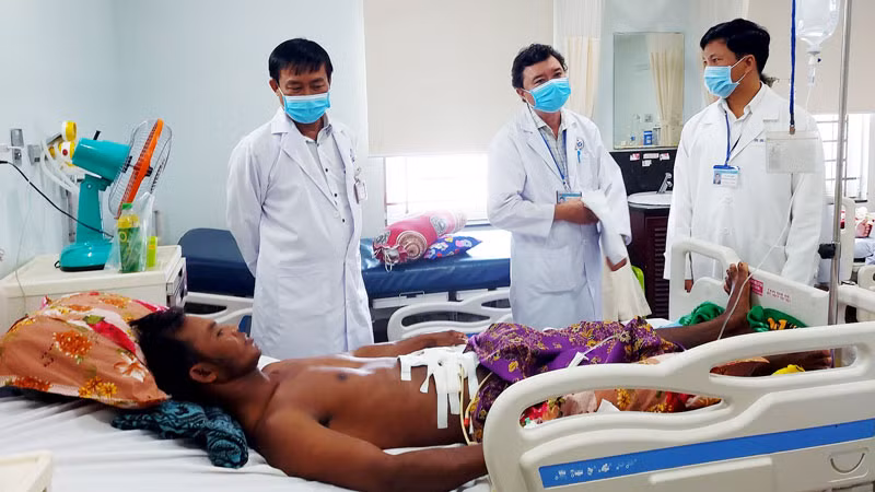 Các bác sĩ Bệnh viện đa khoa tỉnh Kiên Giang thăm khám sức khỏe ông Nhoem Slat, người bị trâu húc thủng bụng.