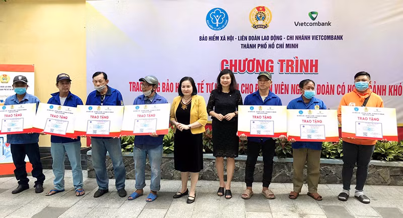 Bà Nguyễn Thị Mỹ Dung, Phó Giám đốc BHXH Thành phố Hồ Chí Minh trao thẻ BHYT tự nguyện cho người có hoàn cảnh khó khăn.