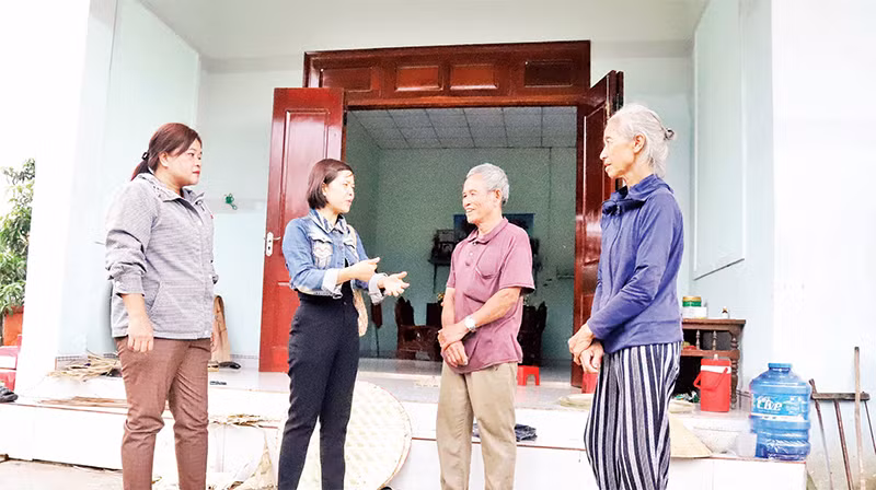 Cán bộ huyện Krông Bông và thị trấn Krông Kmar cùng vợ chồng ông Mai Văn Trung trước ngôi nhà mới có một phần kinh phí từ Quỹ tiết kiệm làm theo lời Bác.