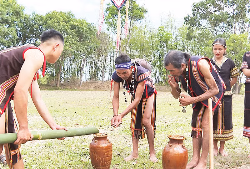Người dân dùng nước được chủ tế hứng vào ống tre để châm vào ghè rượu và mời già làng thưởng thức.