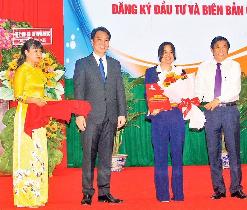 Lãnh đạo tỉnh Vĩnh Long trao giấy chứng nhận cho các nhà đầu tư. (Ảnh BÁ DŨNG)