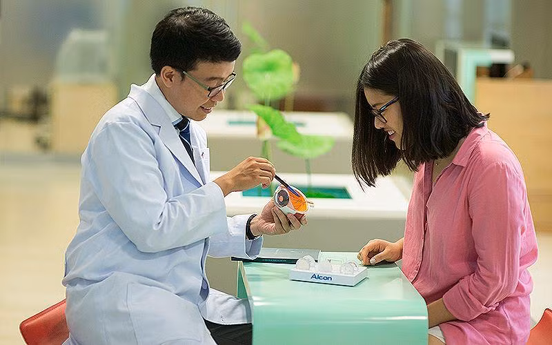 TS, BS Trần Đình Minh Huy (bên trái) chăm sóc, giải đáp thắc mắc của người bệnh. 