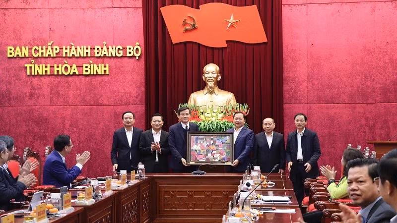 Đồng chí Nguyễn Phi Long, Bí thư Tỉnh ủy Hòa Bình tặng đồng chí Đoàn Minh Huấn, Bí thư Tỉnh ủy Ninh Bình bức tranh mang đậm nét bản sắc văn hóa dân Mường Hòa Bình.