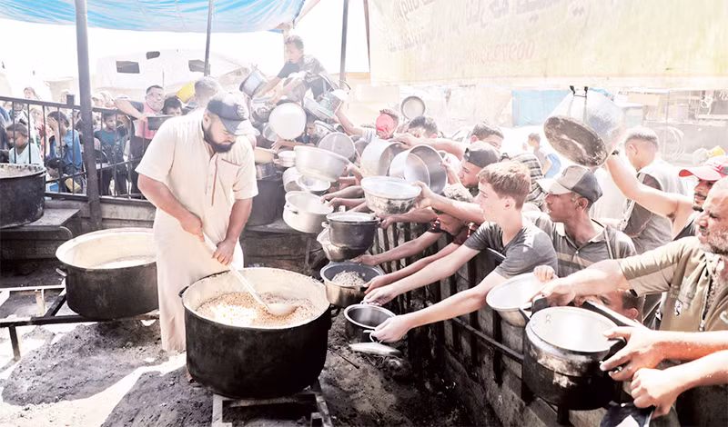 Người dân nhận thực phẩm cứu trợ tại thành phố Khan Younis, Dải Gaza. (Ảnh TÂN HOA XÃ)