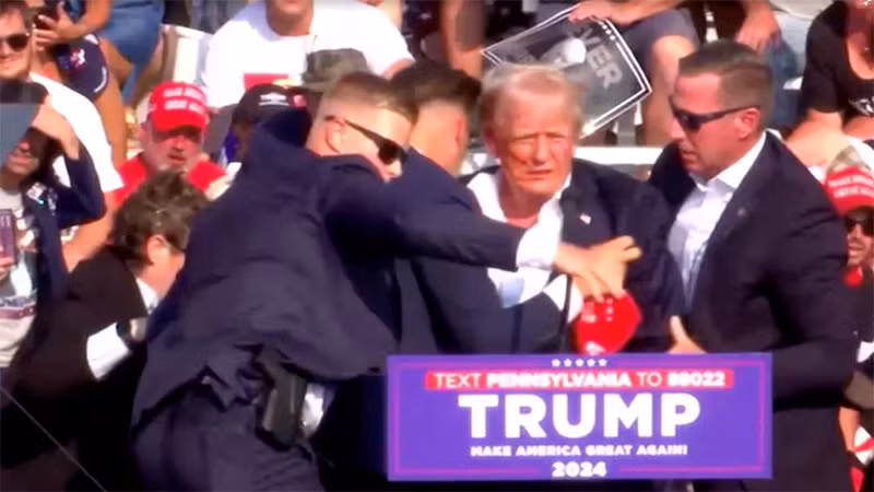 Cựu Tổng thống Mỹ Donald Trump được các mật vụ bảo vệ ngay sau khi tiếng súng xuất hiện. (Ảnh: Reuters)