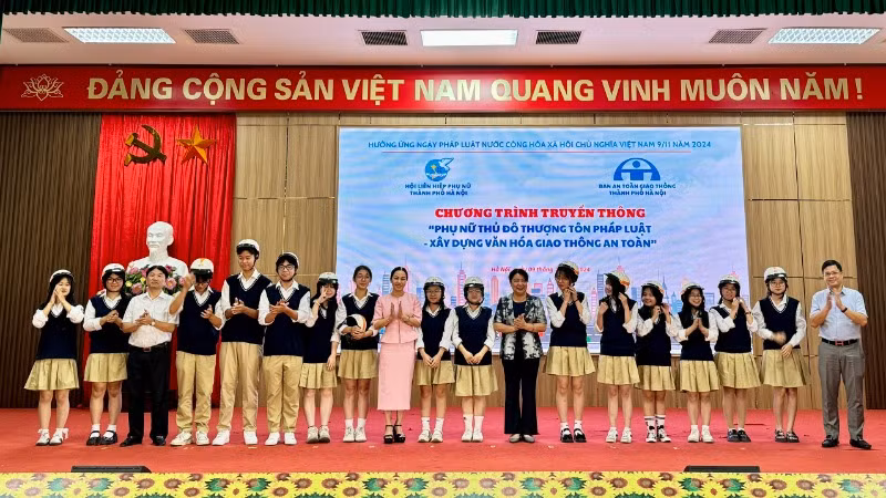 Ban Tổ chức trao mũ bảo hiểm đạt chuẩn tặng các em học sinh.