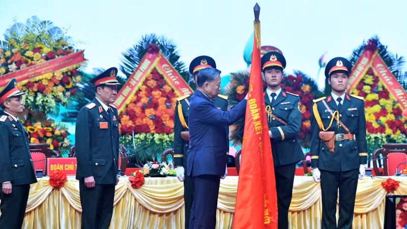 Tổng Bí thư Tô Lâm gắn Huân chương Lao động hạng Nhất lên lá cờ truyền thống Hội Cựu chiến binh Việt Nam. (Ảnh: Đăng Khoa)