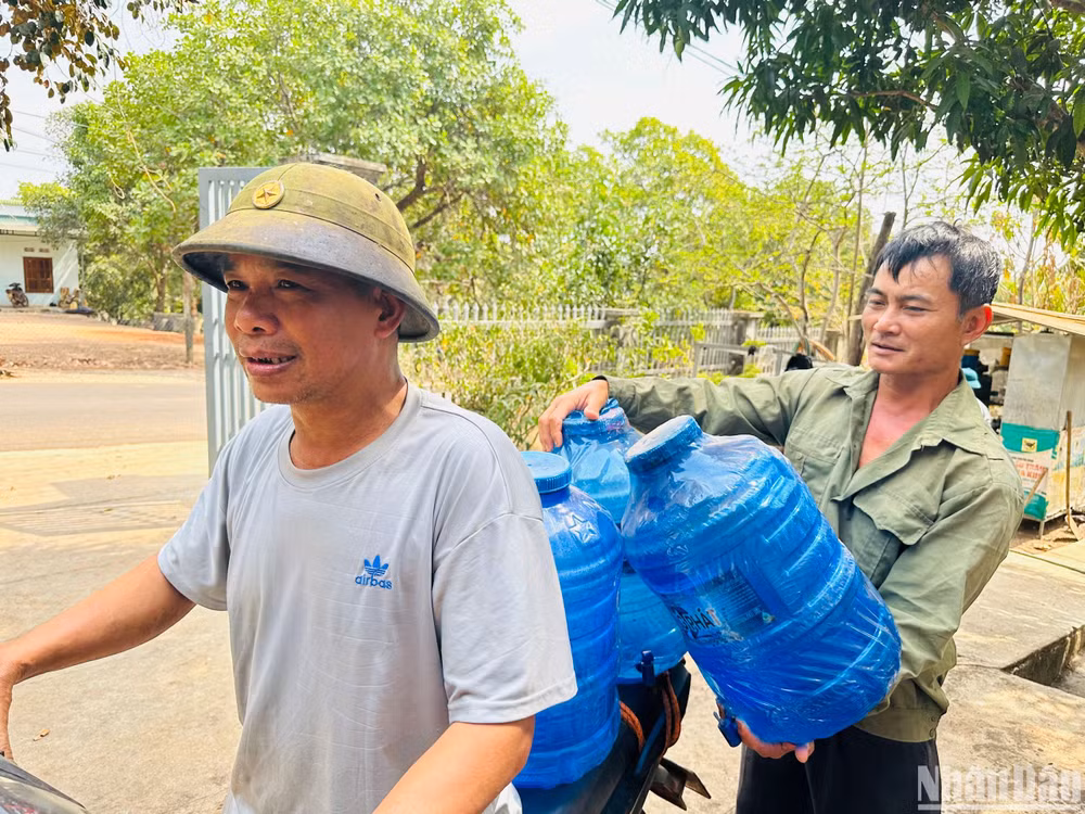 Anh Phạm Văn Mừng cùng anh em trong thôn chuyển bình đến cửa hàng chờ đổi bình nước mới. Anh Phạm Văn Mừng cùng anh em trong thôn chuyển bình đến cửa hàng chờ đổi bình nước mới.