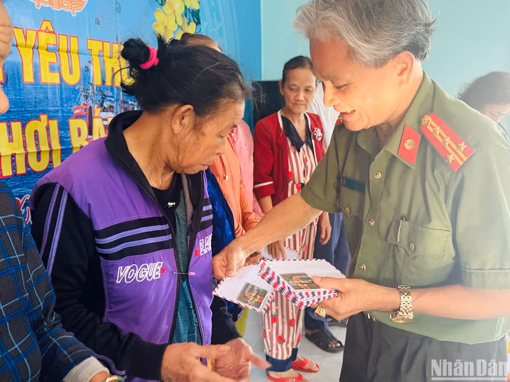 Đại tá Võ Tất Thành, Trưởng phòng An ninh đối ngoại, Công an tỉnh Quảng Ngãi trao quà cho gia đình ngư dân nghèo.