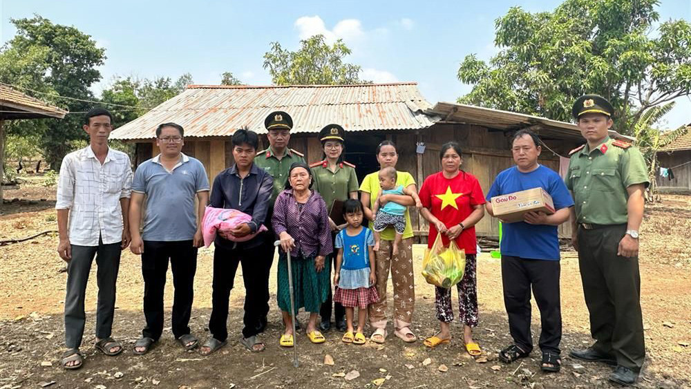 Lực lượng công an trao các nhu yếu phẩm tặng gia đình ông Vương Văn Long sau khi hồi hương. (Ảnh HỒNG LONG)