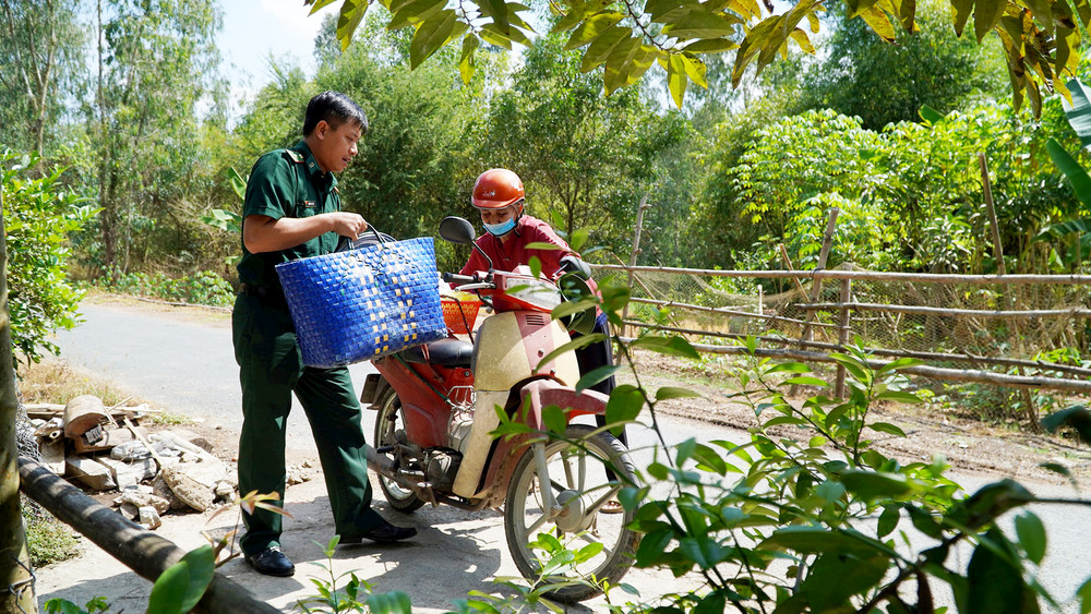 Cán bộ, chiến sĩ Ðồn Biên phòng cửa khẩu quốc tế Dinh Bà giúp người dân trong cuộc sống hằng ngày. 