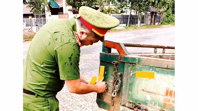 Công an thị xã Buôn Hồ dán decal cho xe công nông của người dân.