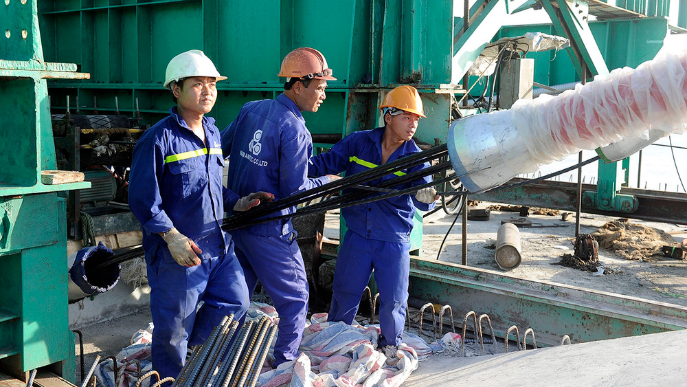 Công nhân lắp đặt thiết bị thông tin tại Nhà máy đóng tàu Hồng Hà (Hải Phòng). (Ảnh ANH SƠN)