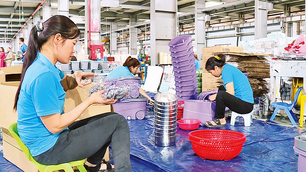 Người lao động tại Công ty TNHH sản xuất nhựa Việt Nhật (huyện Thanh Oai) bắt tay ngay vào công việc từ những ngày đầu xuân. (Ảnh DUY LINH)