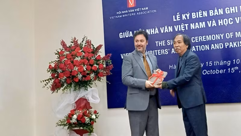 Chủ tịch Hội Nhà văn Việt Nam Nguyễn Quang Thiều (phải) tặng quà cho phía Pakistan.