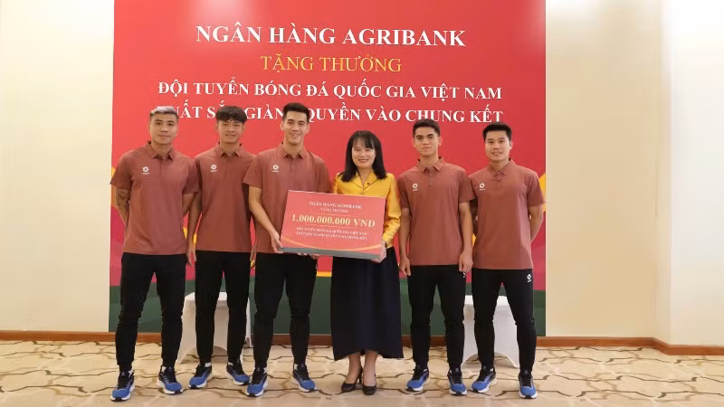 Bà Phùng Thị Bình - Phó Tổng Giám đốc Agribank trao thưởng 1 tỷ đồng cho đại diện Đội tuyển bóng đá quốc gia Việt Nam.